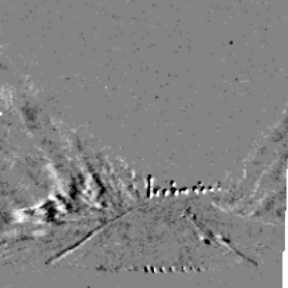 Event-camera frame of a night-time road: the lane edges and a line of reflector posts are still clearly resolved.